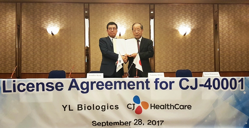 사진1. CJ헬스케어 강석희 대표(왼쪽)와 YL Biologics의 토시히코 히비노 대표(오른쪽)가 계약서를 들고 기념사진을 찍고 있다. 